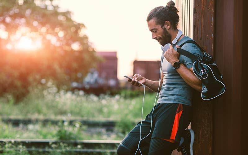 A man in workout clothes looking on his phone. A man in workout clothes looking on his phone.