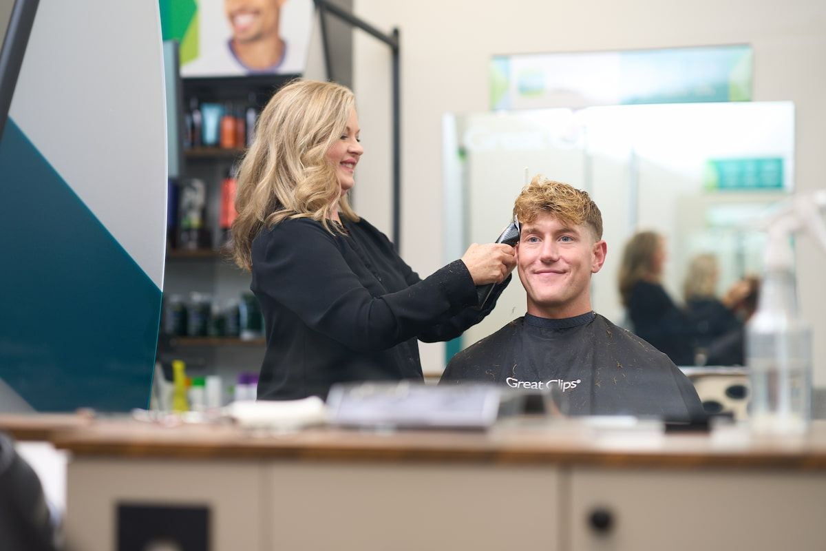 A man sitting in a Great Clips salon chair getting a haircut A man sitting in a Great Clips salon chair getting a haircut